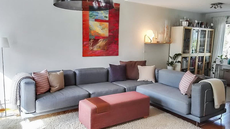 A grey Tylosand sectional in a modern, red-accented living room