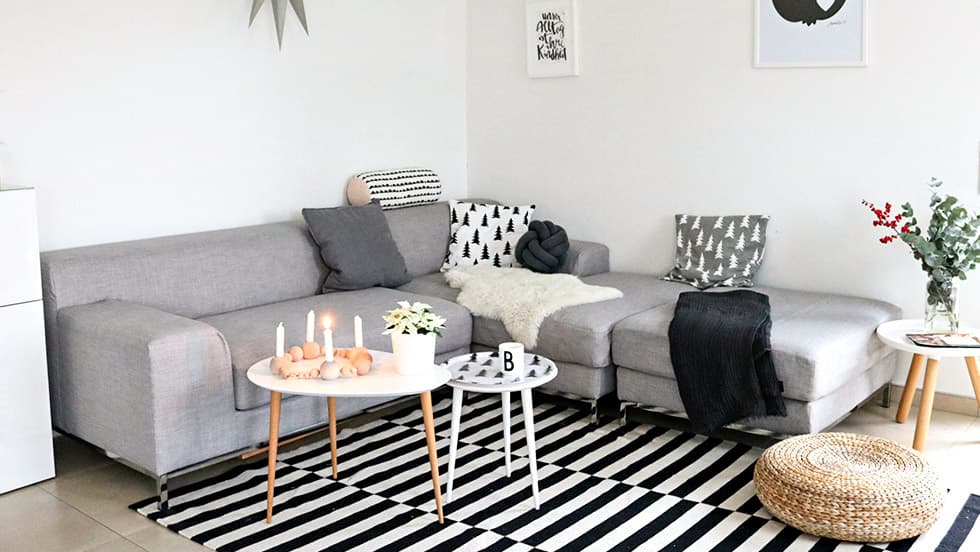A cool grey modular IKEA Kramfors corner sofa in a modern, black and white themed living room