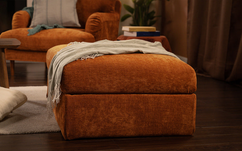 An IKEA Vimle footstool with a machine washable and wrinkle free Performance Weave Burnt Orange cover in a decorated living room