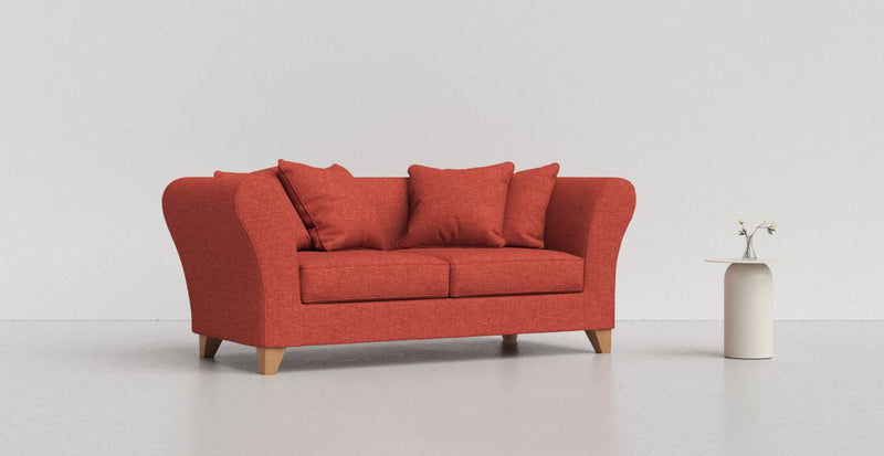 A dark red Backa sofa on a light grey background with a white vase beside it