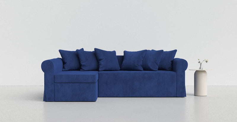A royal blue Moheda sofa on a light grey background with a white vase beside it