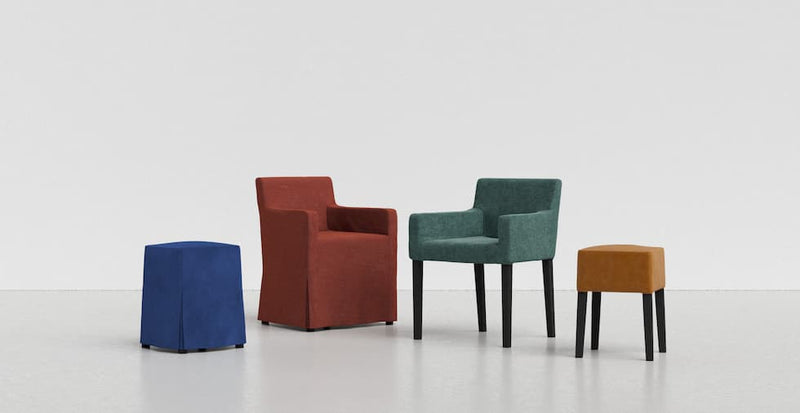 A collection of IKEA Nils armchairs and bar stools in covers of varying skirt lengths and jewel-toned blue, red, green and yellow