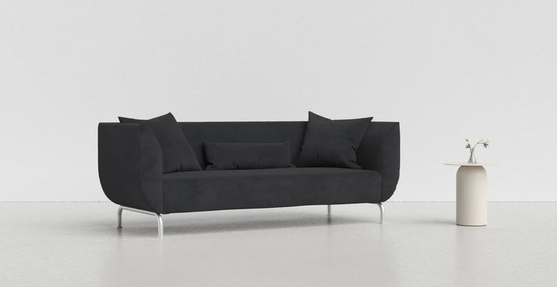 A midnight blue IKEA Stromstad sofa on a light grey background with a white vase beside it