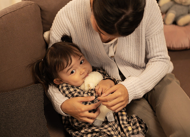 Close-up of a girl and child cuddling on an IKEA KARLSTAD three-seater sofa with Everyday Linen Hazel slipcover