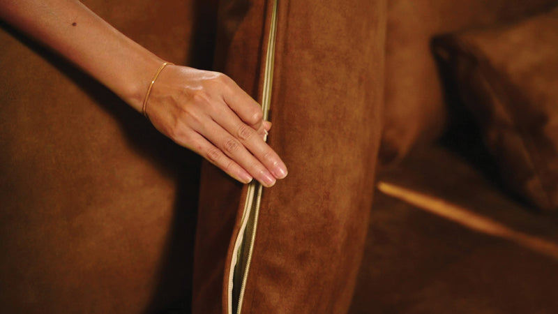 Hand zipping up Comfort Works couch cushion cover Signature Velvet in Caramel colour