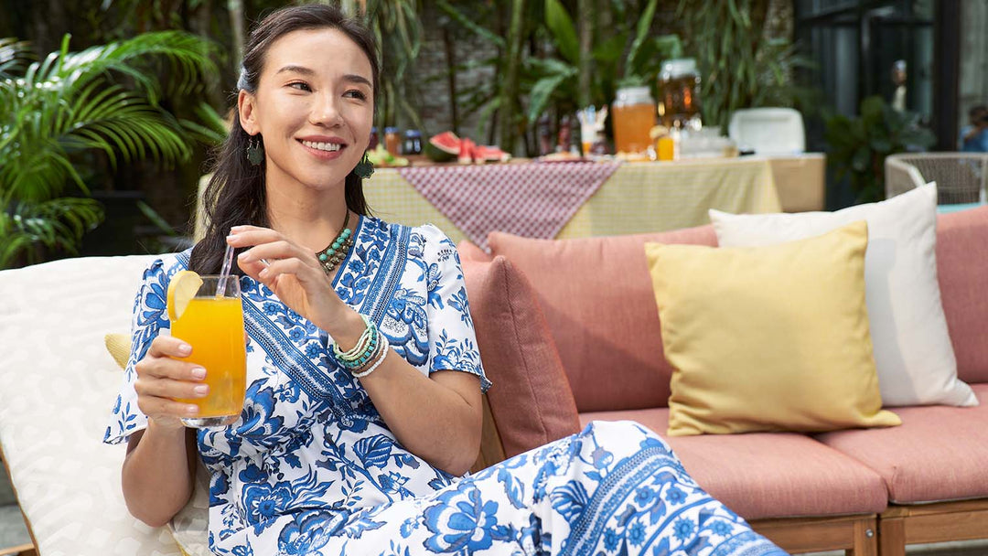Lady-enjoying-her-orange-drink-on-her-outdoor-sofa-in-the-summer