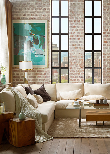 Bright loft-style living room with a white sofa slipcover, featuring custom couch covers for a cosy and elegant space