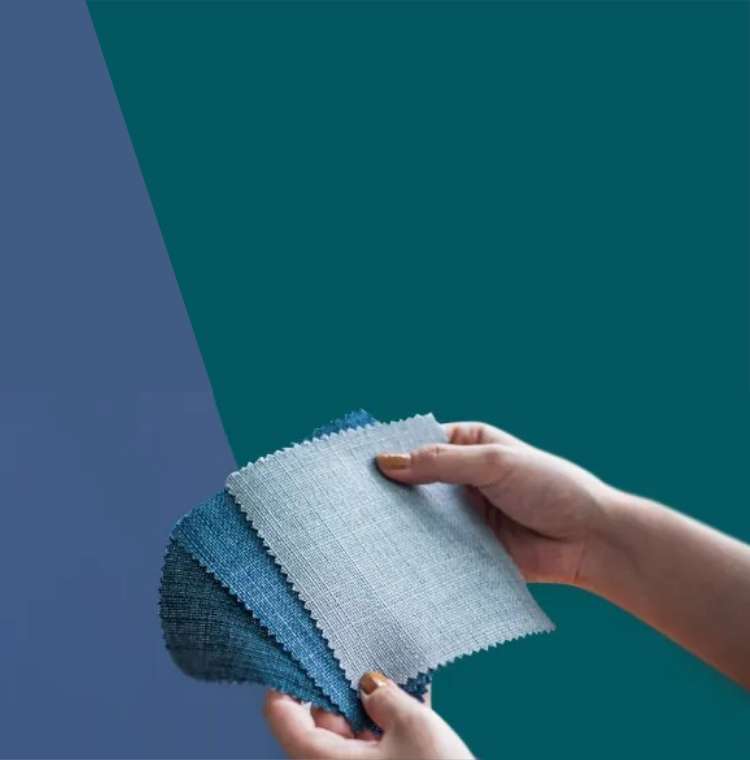 Hand holding grey and blue tone fabric swatches