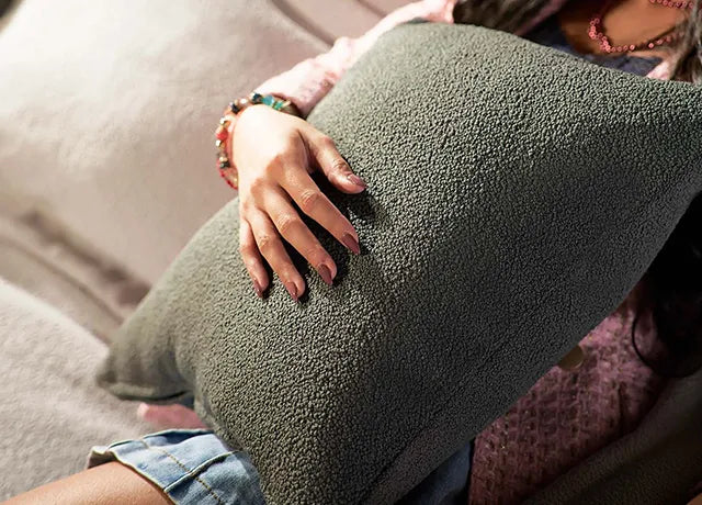 Closeup-of-stylish-girl-holding-cushion-while-sitting-on-sofa-ComfortWorks-Mod-Boucle-in-Charcoal