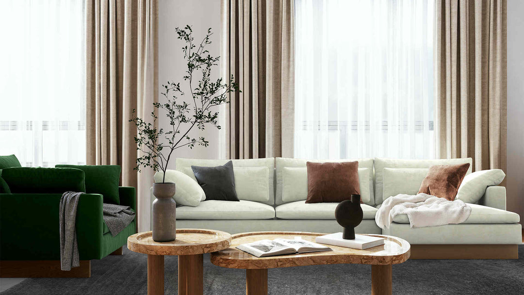 Modern living room with West Elm Harmony sofa in Performance Weave Stone and Classic Velvet Forest Green slipcover