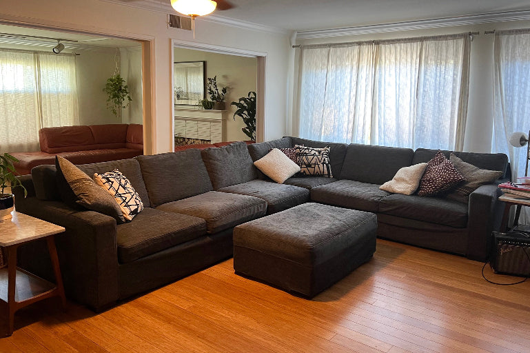 Spacious living room with a dark grey sofa slipcover from Comfort Works, featuring custom couch covers for a sleek, modern look and added furniture protection