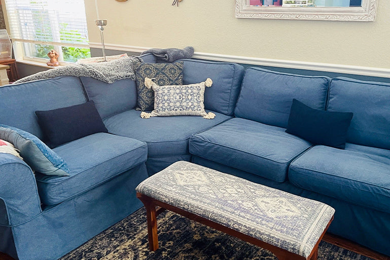 Cosy living room with a blue sofa slipcover from Comfort Works, featuring custom couch covers for a snug fit and a refreshed, stylish look