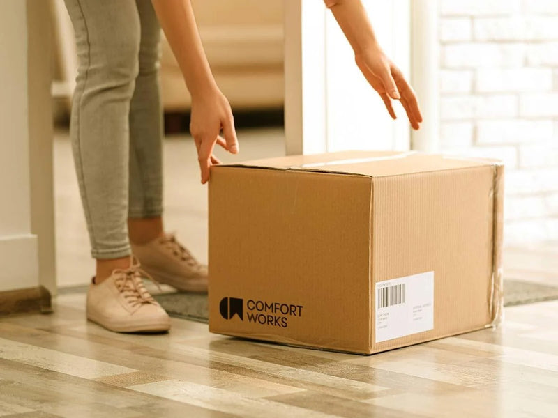 Man picking up a package box from Comfort Works