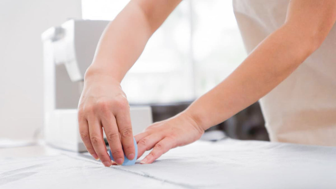 Slipcover pattern maker using chalk to draw the pattern shape