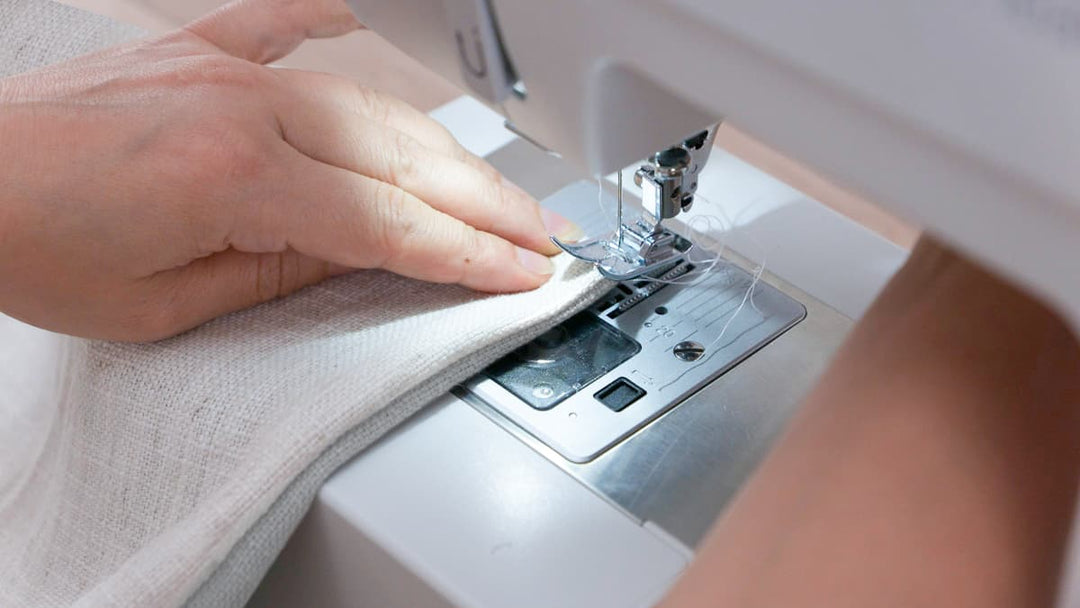 Close-up of a fabricator sewing a slipcover using a sewing machine