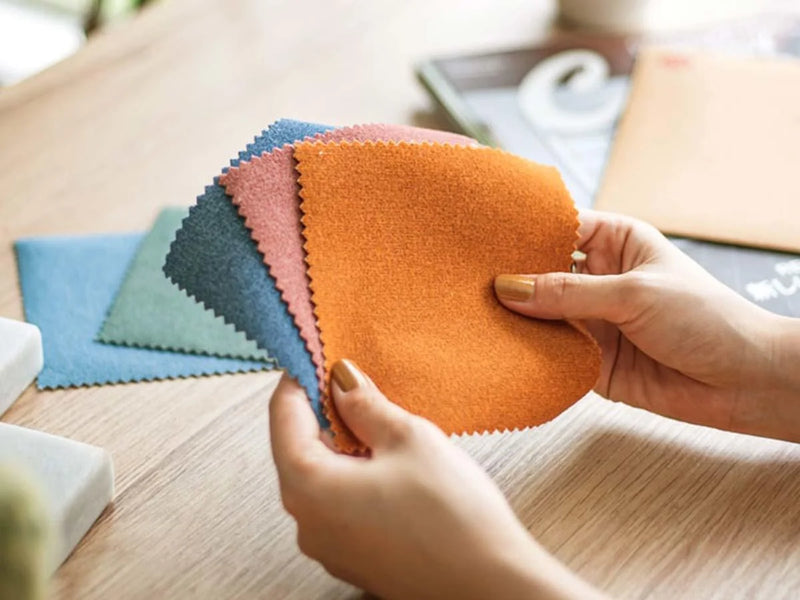 Hand holding fabric sample swatches with a variety of color options