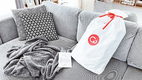 Comfort Works drawstring bag on a sofa couch with Textured Weave Ash slipcover