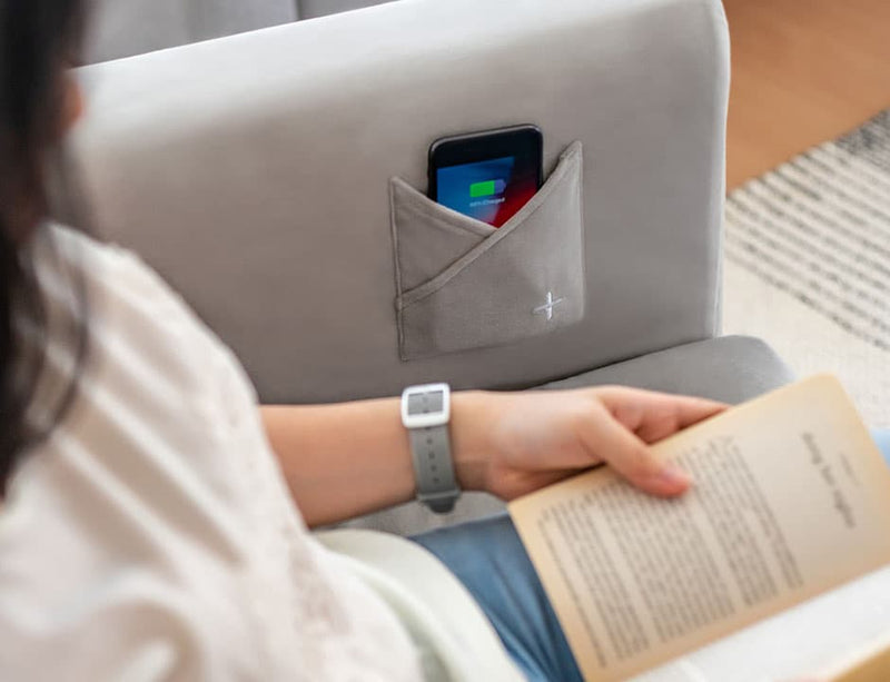 Close-up of mobile phone charging with a sofa slipcover with smart accessories